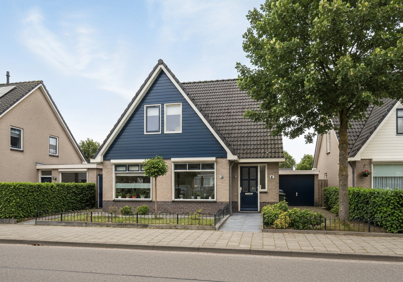 Nederlandse vrijstaande woning met Keralit gevelbekleding in donker navyblauw op de topgevel-driehoek, baksteen op de rest van de gevel